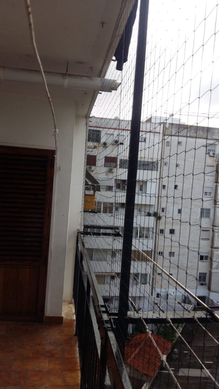 Red tensada con poste y anclajes en un balcón